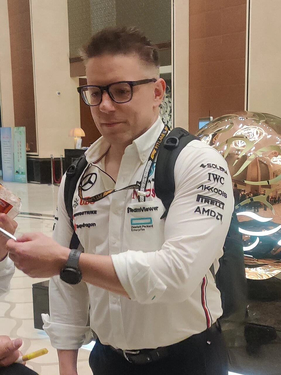 Peter Bonnington standing indoors wearing glasses and a Mercedes-AMG Petronas team shirt