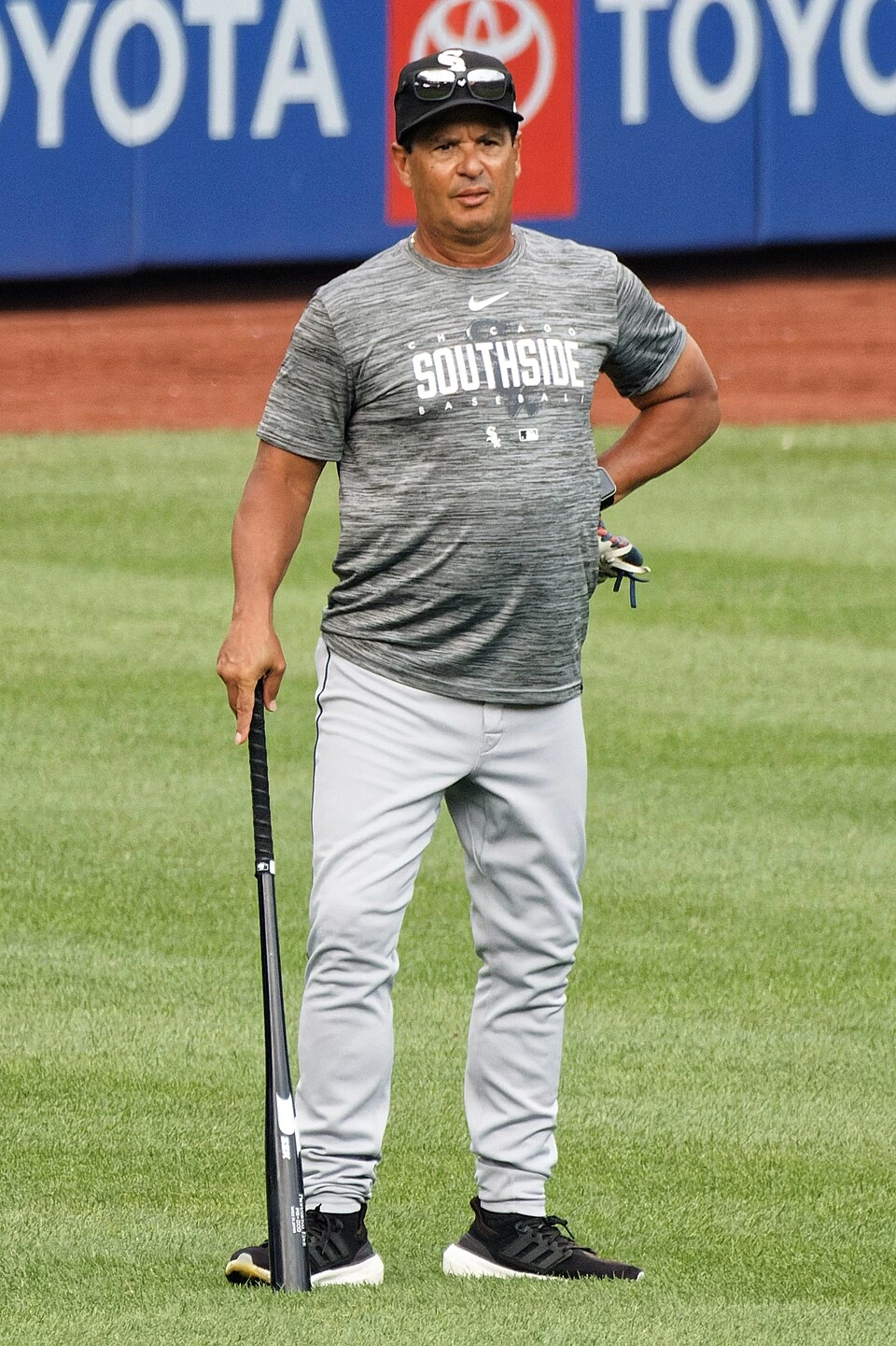 Charlie Montoyo standing on a baseball field holding a bat
